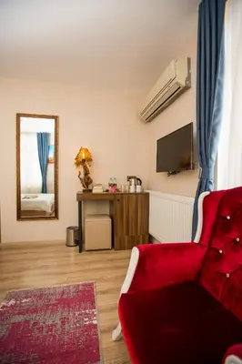 a living room with a red couch and a mirror at Corner Garden Hotel in Istanbul