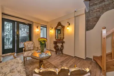 a living room with a table and a chair at Corner Garden Hotel in Istanbul