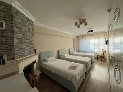 a hotel room with two beds and a fireplace at Doğa Villa Guest House in Buyukcekmece