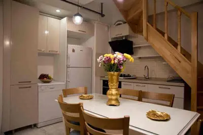 a kitchen with a table with a vase of flowers on it at Nupelda Residence Hotel in Istanbul