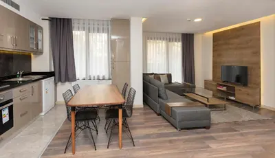 a kitchen and living room with a table and a couch at Princess Residence in Istanbul