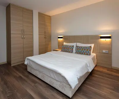 a bedroom with a large white bed and wooden floors at Princess Residence in Istanbul