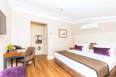a hotel room with a large bed and a desk at Meroddi La Porta in Istanbul