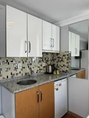a kitchen with white cabinets and a sink at Tavra hotel in Istanbul