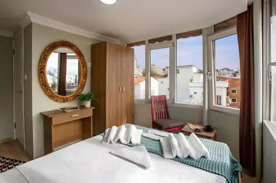 a bedroom with a bed with a mirror and windows at Sofia Corner Hotel in Istanbul