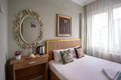 a bedroom with a bed with a mirror on the wall at Sofia Corner Hotel in Istanbul