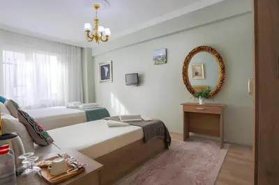 a bedroom with two beds and a mirror on the wall at Sofia Corner Hotel in Istanbul