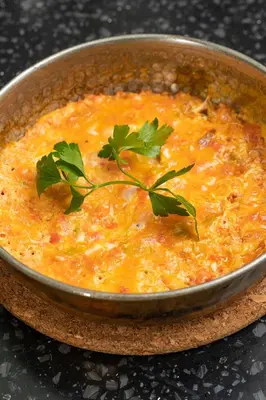 a metal bowl of soup with a garnishment in it at Elm Suite Hotel in Istanbul