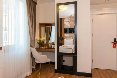 a room with a mirror and a desk with a chair at Eastanbul Suites in Istanbul