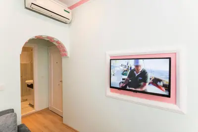 a television hanging on a wall in a living room at TAXİM ELEGANCE SUİTES in Istanbul