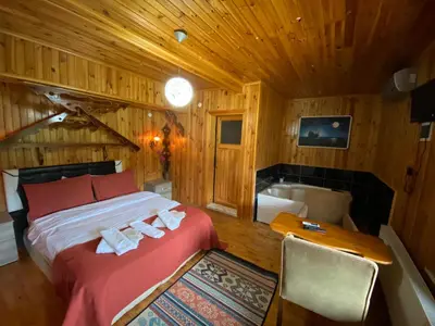 a bedroom with a bed and a desk and a tub at Ağva Green River Hotel in Agva