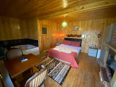 a bedroom with a bed and a table and a tub at Ağva Green River Hotel in Agva