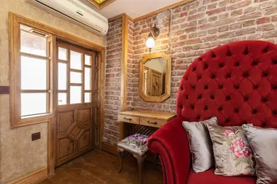 a red couch in a room with a brick wall at Enderun by Otantik Suites in Istanbul