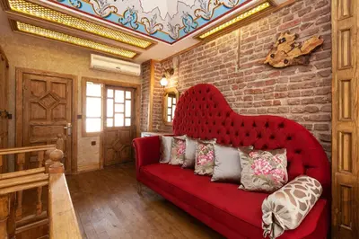 a red couch in a room with a brick wall at Enderun by Otantik Suites in Istanbul