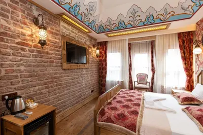 a bedroom with a brick wall with a bed and a tv at Enderun by Otantik Suites in Istanbul