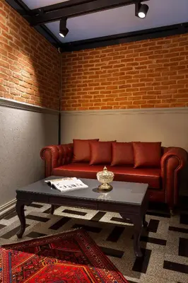 a living room with a red couch and a coffee table at Güner Business Hotel in Istanbul