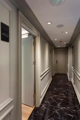a hallway with a black marble floor in a building at Güner Business Hotel in Istanbul