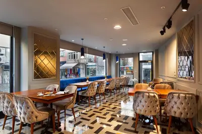 a restaurant with wooden tables and chairs and windows at Güner Business Hotel in Istanbul