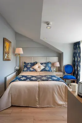 a bedroom with a bed and a blue chair at Güner Business Hotel in Istanbul