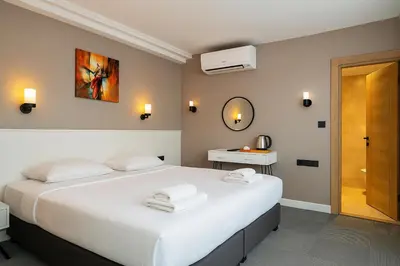 a bedroom with a large white bed and a mirror at Blue Point Hotel in Istanbul