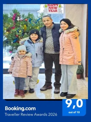 a man and two children standing in front of a christmas tree at Gul Otel in Istanbul