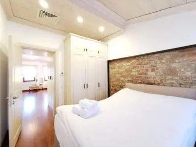 a bedroom with a white bed and a brick wall at Ottobalat in Istanbul