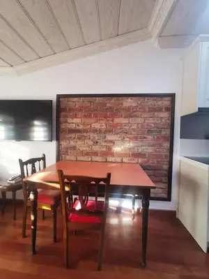a dining room table with chairs and a brick wall at Ottobalat in Istanbul