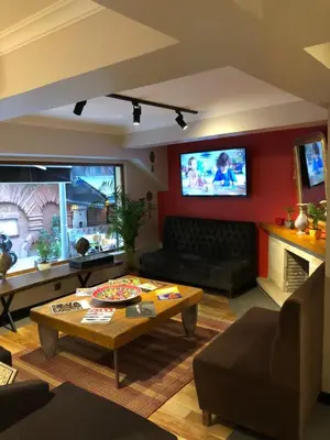 a living room with a table and a tv on the wall at Nomade Old City Hotel in Istanbul