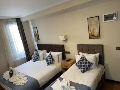 a hotel room with two beds and a window at Nomade Old City Hotel in Istanbul