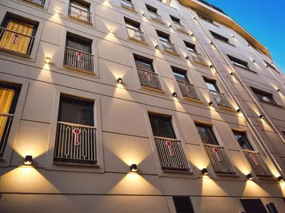 a large white building with windows and lights on it at Stayso The House Hotel in Istanbul