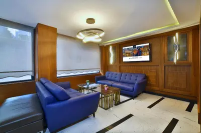 a living room with blue couches and a tv at The Tango Hotel Taksim in Istanbul