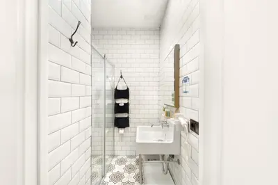 a bathroom with a sink and a white tiled wall at Hotel Des Arts Galata in Istanbul