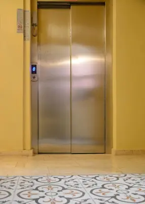 a metal elevator in a hallway with a tile floor at madame roza in Istanbul