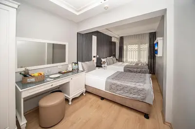 a bedroom with a bed and a desk with a mirror at Beyazit Palace Hotel in Istanbul