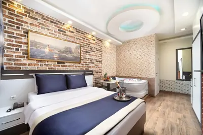 a bedroom with a bed and a brick wall at İstanbul Hotel & Suites in Istanbul