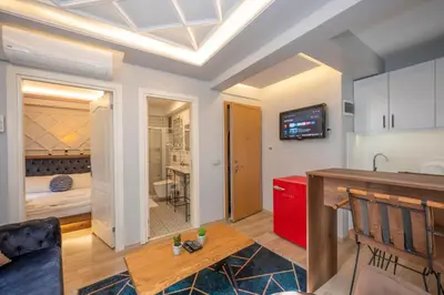 a living room with a table and a kitchen at Dorne Suite Taksim Hotel in Istanbul