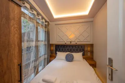 a bedroom with a bed with a blue and white pillow at Dorne Suite Taksim Hotel in Istanbul