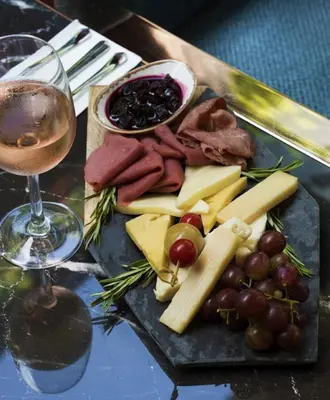 a plate of cheese and meats and a glass of wine at No2 Hotel By Şükrü in Adalar