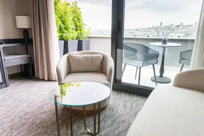 a room with a chair and a table and a balcony at MEG HOTEL in Istanbul