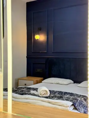 a bedroom with a bed with a blue wall at The Reina Hotel in Istanbul