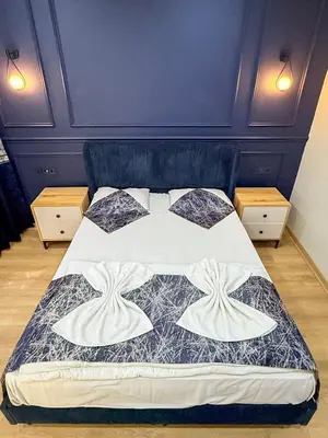 a bedroom with a bed with a blue headboard at The Reina Hotel in Istanbul