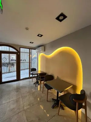 a waiting room with tables and chairs and a window at The Reina Hotel in Istanbul