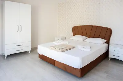 a bedroom with a large bed with a wooden headboard at Araz Suit in Burgaz