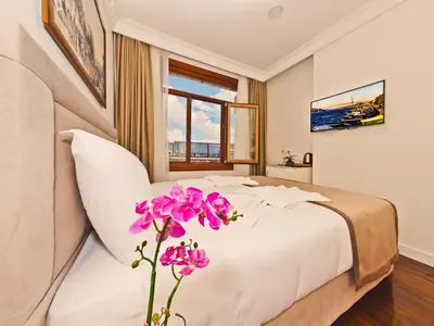 a bedroom with a bed and a vase of flowers at Nusretbey Hotel in Istanbul