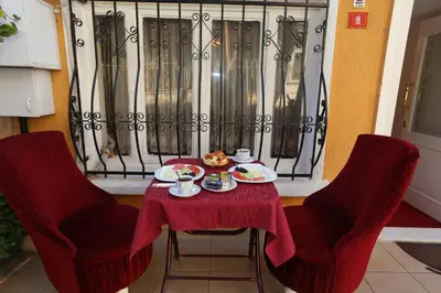 a table with two chairs and a plate of food on it at Masal Hotel in Buyukada
