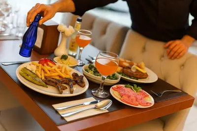 a table with plates of food and glasses of wine at Grand Hotel Avcılar in Istanbul