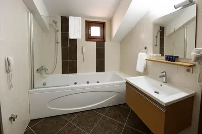 a white bathroom with a tub and a sink at Grand Hotel Avcılar in Istanbul