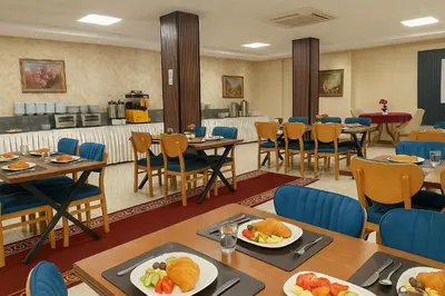 a restaurant with tables and chairs with food on them at Grand Hotel Avcılar in Istanbul