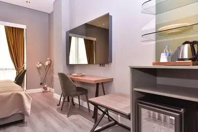 a living room with a table and a mirror at Atacity Hotel in Istanbul