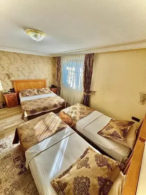 a hotel room with three beds and a window at Grand Papirus Hotel in Istanbul